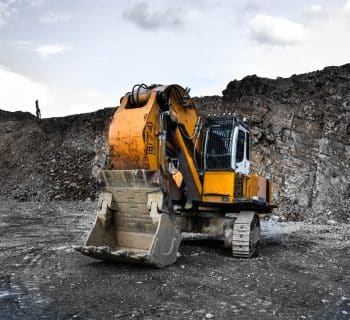 yellow and black excavator near hill