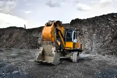 yellow and black excavator near hill