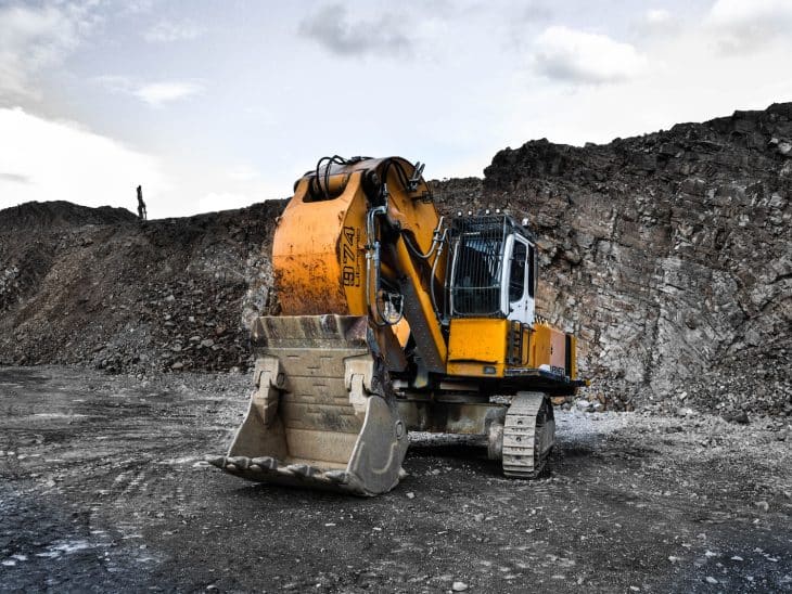 yellow and black excavator near hill