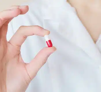 Crop nurse demonstrating small double colored pill