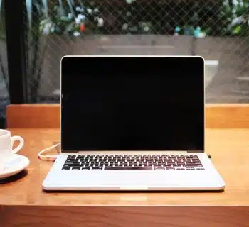 laptop computer beside coffee mug