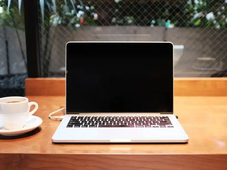 laptop computer beside coffee mug